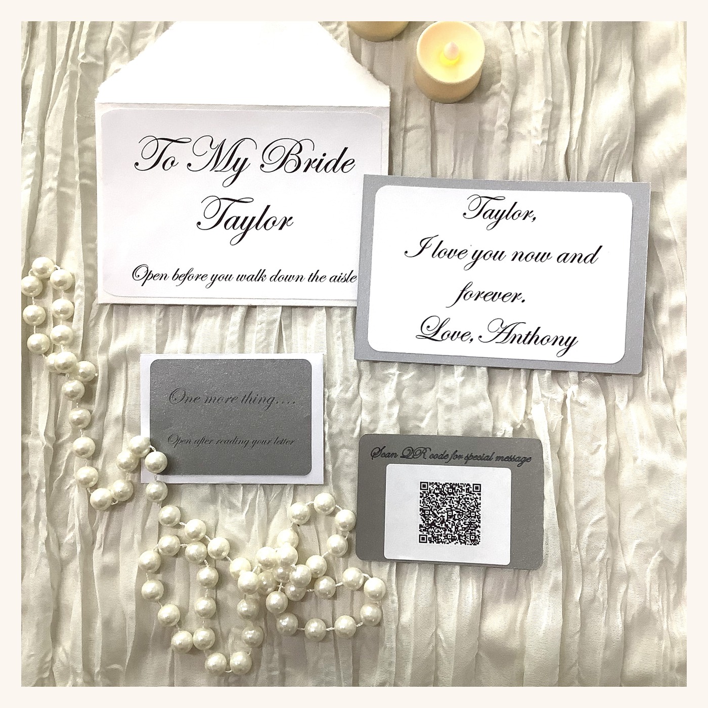 Printed 'To My Bride' letter card, keepsake note, and QR video card arranged with pearls and candlelight