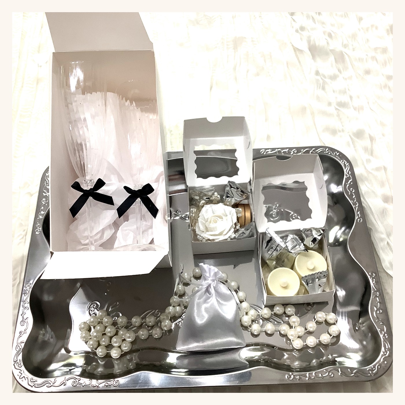 Silver tray with celebration flutes, preserved rose keepsake box, and sweets boxes