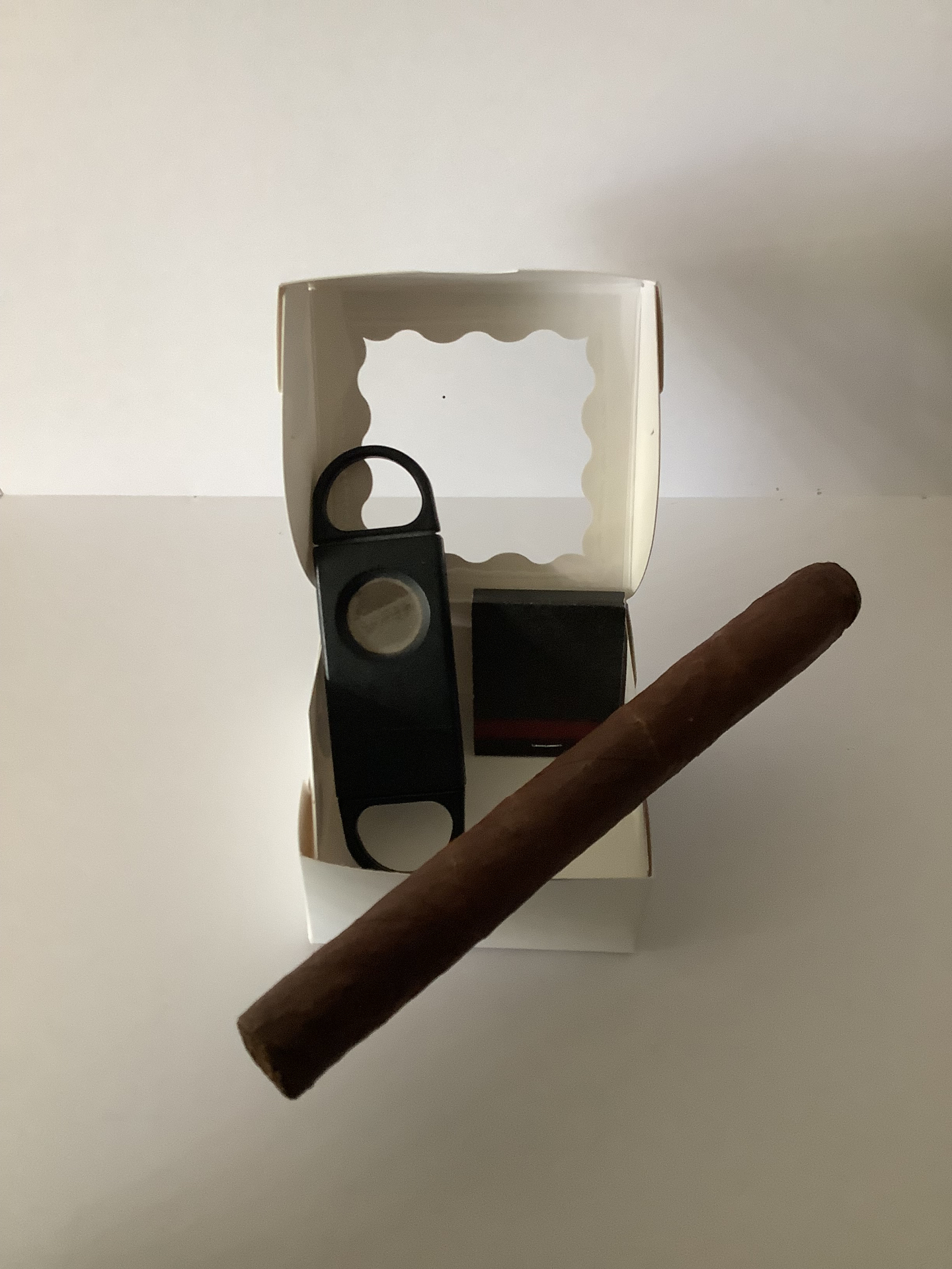 Premium cigar with black cutter and matches